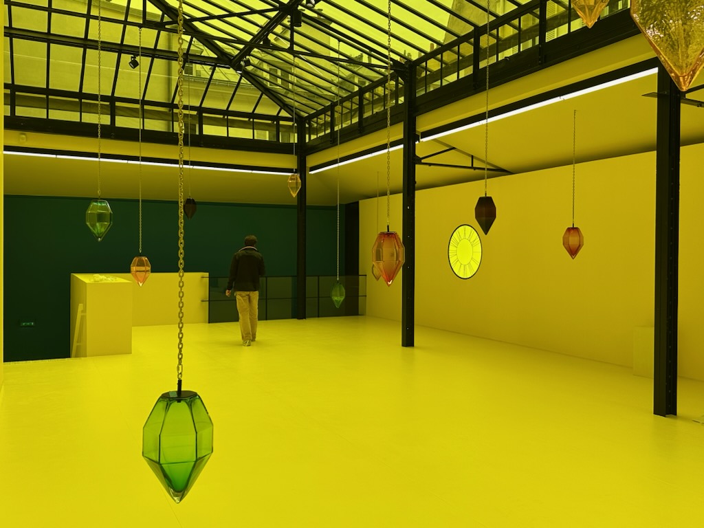 Vue de l'installation en cours d'une exposition avec des œuvres suspendues à une verrière, faisant partie de nos services de régie d'art.